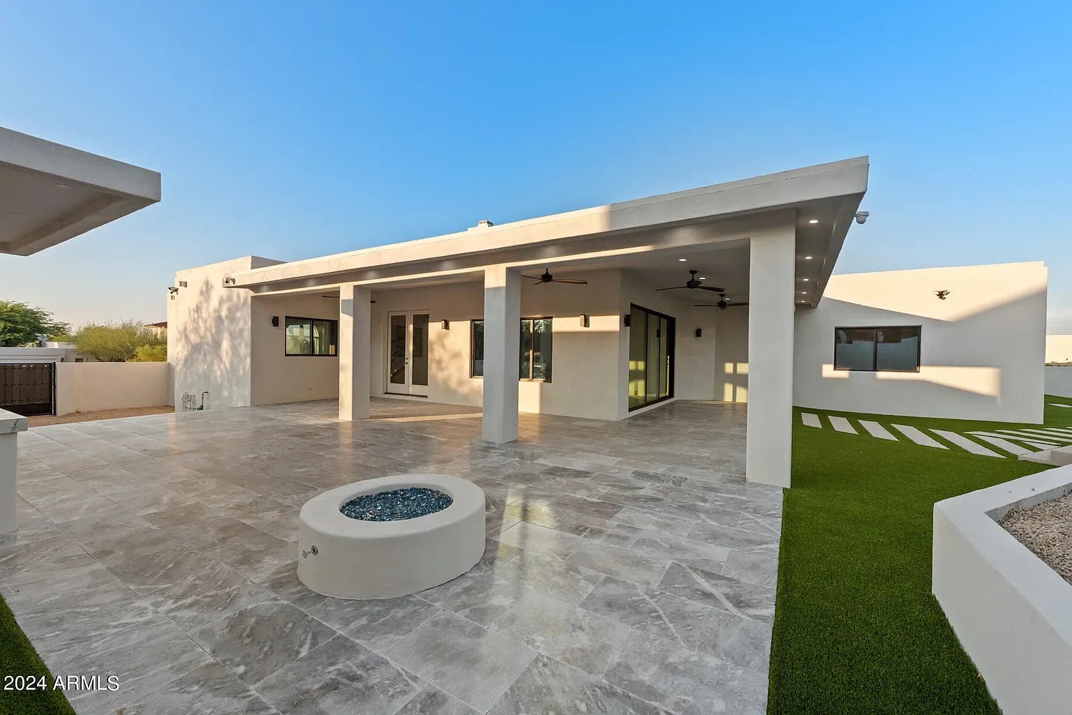 Fire Feature Terrace: Covered terrace with a gas fire feature and large-format travertine. Gas line, slab and finish set by one crew.