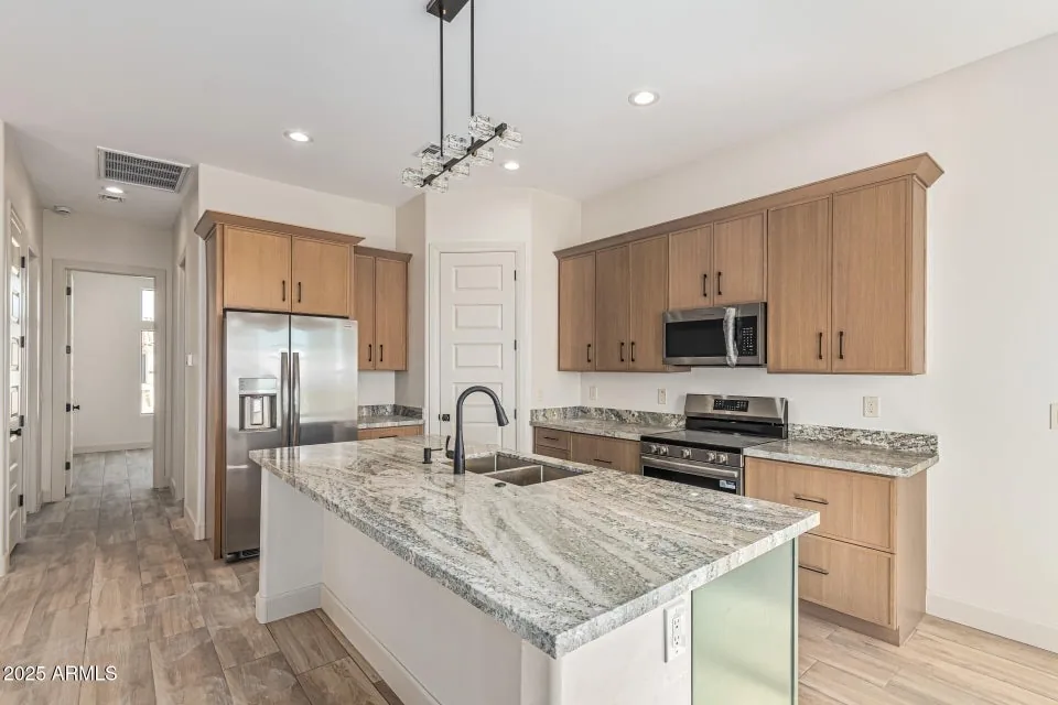 Granite Island Kitchen: Full-height cabinetry with a granite island and a clean appliance wall. Plumbing and electrical rough-in by our licensed crews.