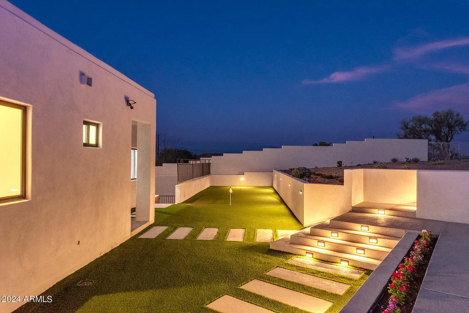 Lit Step Backyard: Tiered backyard with lit risers and a turf field. Site work, retaining and electrical under a single contract.