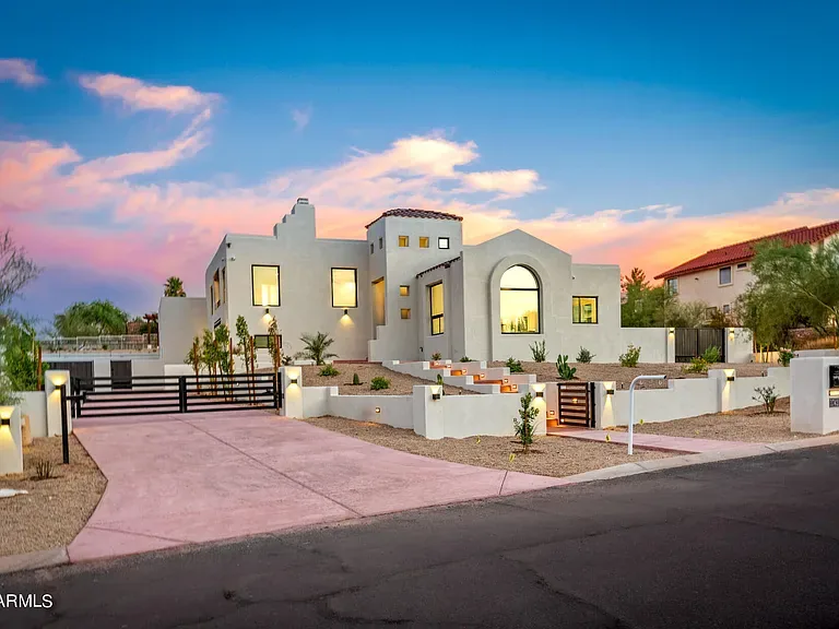 Twilight Elevation: Desert-contemporary front elevation photographed at dusk. Stucco, steel and stone detailing carried through to the street.