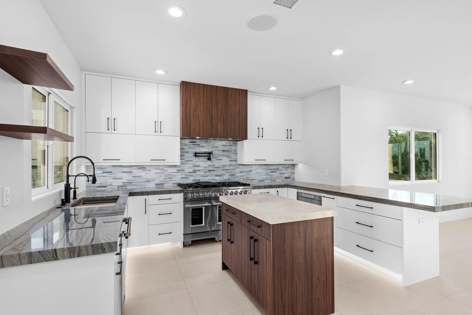 Walnut Island Kitchen: Flat-panel perimeter in white with a contrasting walnut island, slab backsplash and undercabinet lighting.